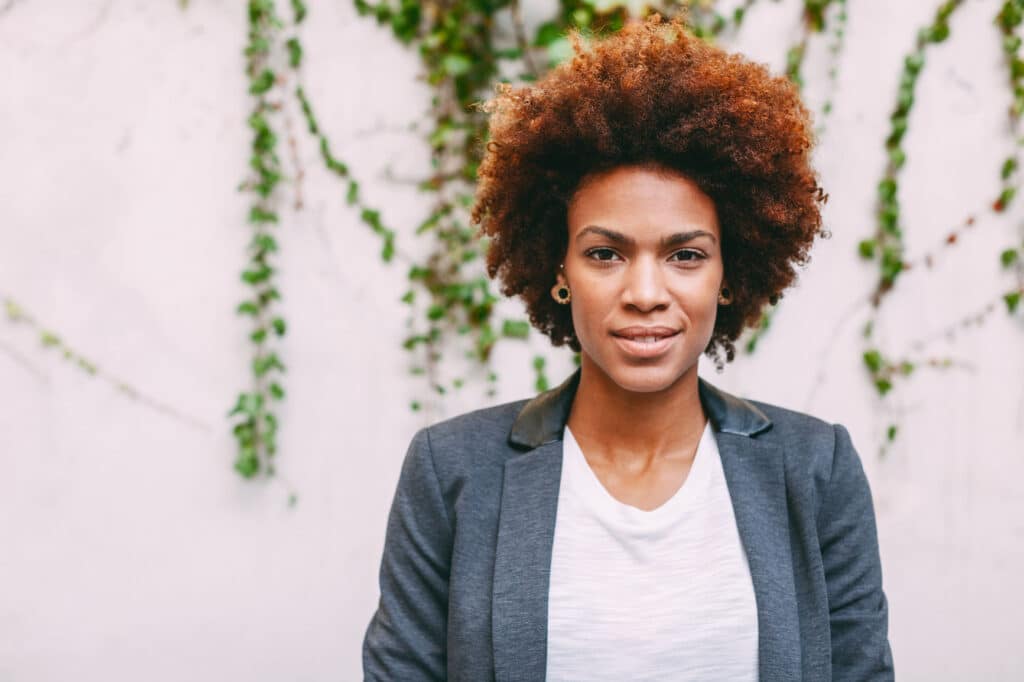 portrait of woman standing in front of ivy background