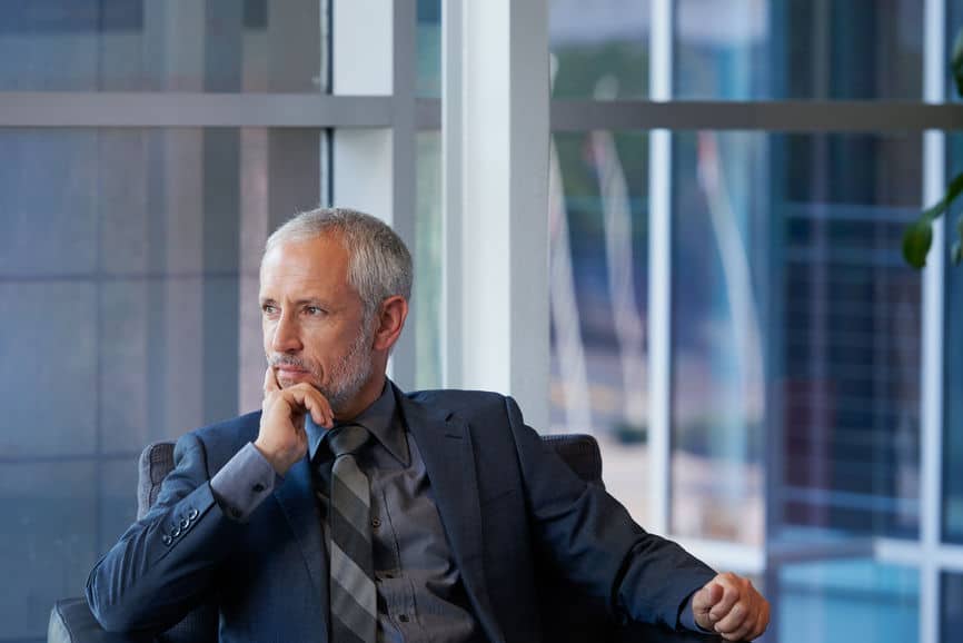 Businessman in suit staring out office window